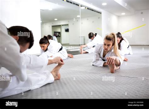 Martial artists doing leg splits while warming up for taekwondo ...