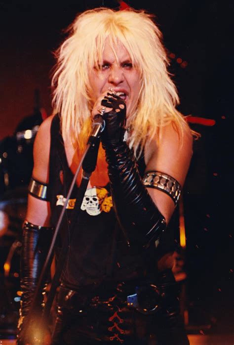 a woman with long blonde hair holding a microphone in front of her face ...