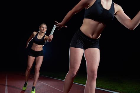 athletic runners passing baton in relay race 12651095 Stock Photo at ...