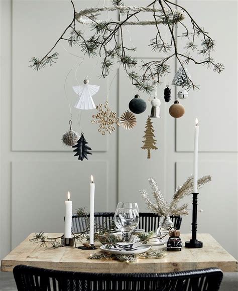 a dining room table decorated for christmas with ornaments hanging from ...