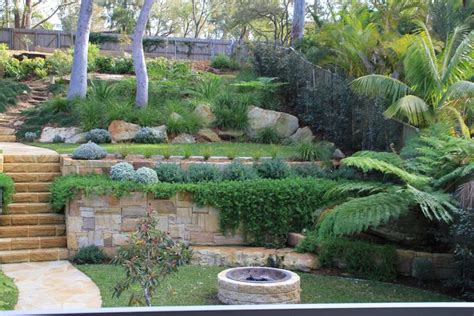 an outdoor garden with stone steps and plants on the hillside ...