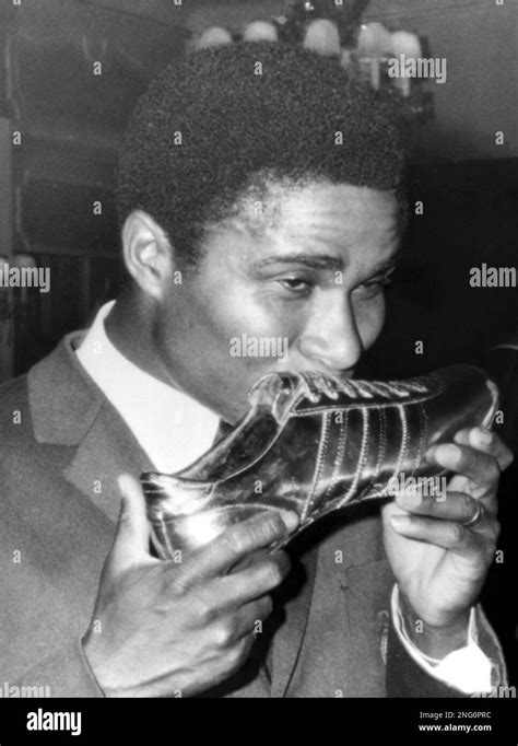 Portugal's soccer star Eusebio kisses the golden shoe he was awarded with after being voted as ...