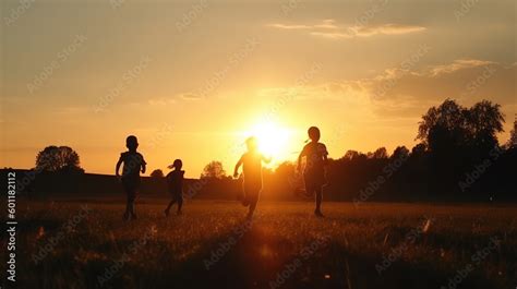 Children silhouette walking in the sunset park, play together in nature. Happy kids running at ...