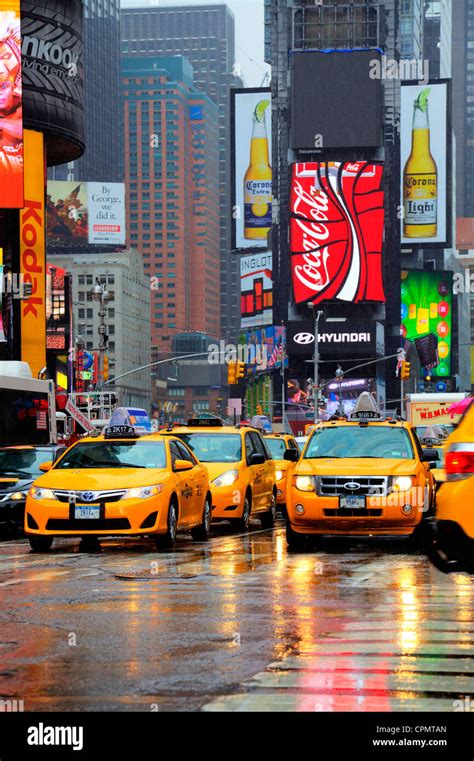 Iconic New York yellow taxis in Times Square, Manhattan. Reflections ...