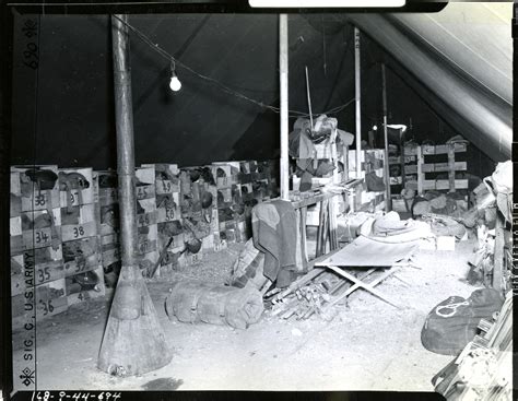 Interior of tent where barracks bags field packs, rifles and other ...