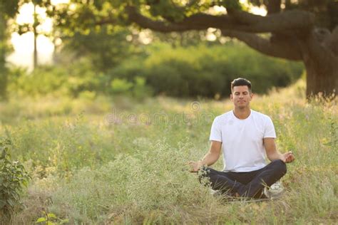 Man Meditating on Green Grass in Park, Space for Text Stock Image - Image of nature, feeling ...