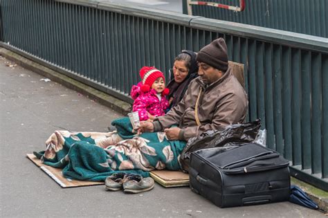 Homeless Family Sitting On The Street Stock Photo - Download Image Now ...