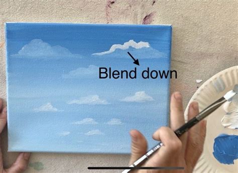 two hands holding paintbrushes over a painting with the words blend down on it