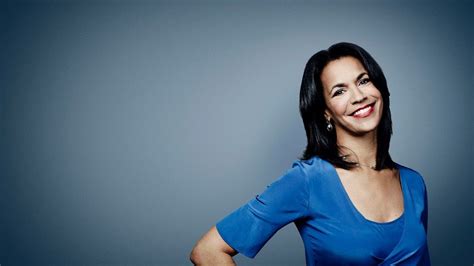 a smiling woman in a blue dress posing for a photo with her hands on ...