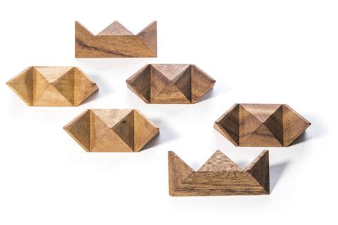 six wooden shapes are arranged in the shape of an origami crown on a white background