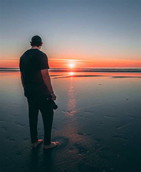 Man Standing on Beach during Sunset · Free Stock Photo