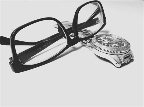 Grayscale Photography of Black Framed Eyeglasses on Watch · Free Stock Photo