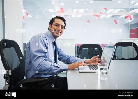 Businessman using a laptop and smiling Stock Photo - Alamy