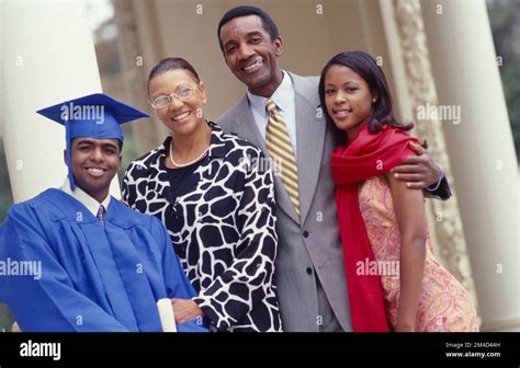 African-American family posing outside with new graduate son cap and gown Stock Photo - Alamy