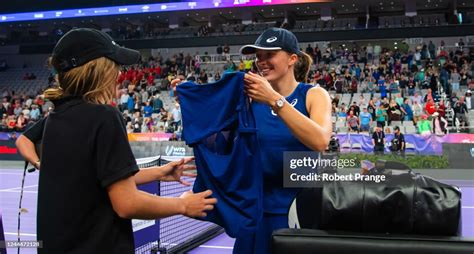 Iga Swiatek of Poland gifts one of her match outfits to a ballgirl... News Photo - Getty Images