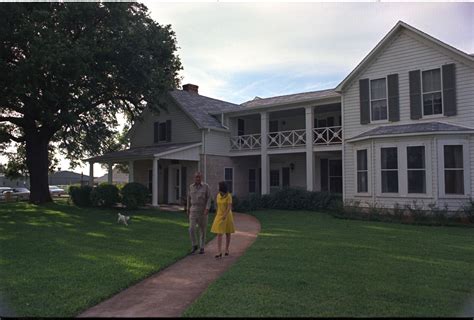 President Lyndon B. Johnson, Lady Bird Johnson, and their dog Yuki in front of the Ranch House ...