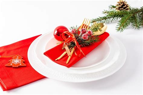 Premium Photo | White plates with red napkins and Christmas decorations on a white background ...