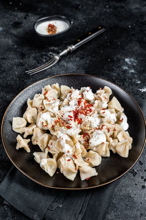 Turkish Manti with Yoghurt and Tomato Sauce in a Plate. Black ...