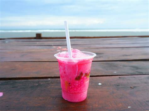 Es Podeng or Pink drink on a wooden table with Beach Background ...