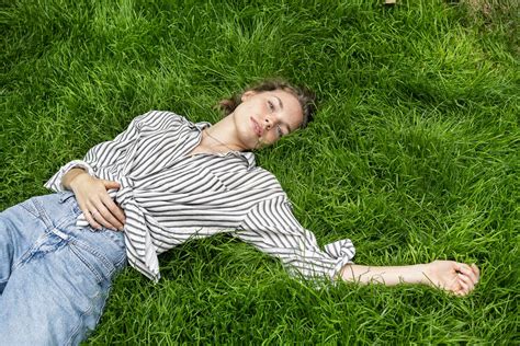 Young woman lying on grass, looking at camera stock photo