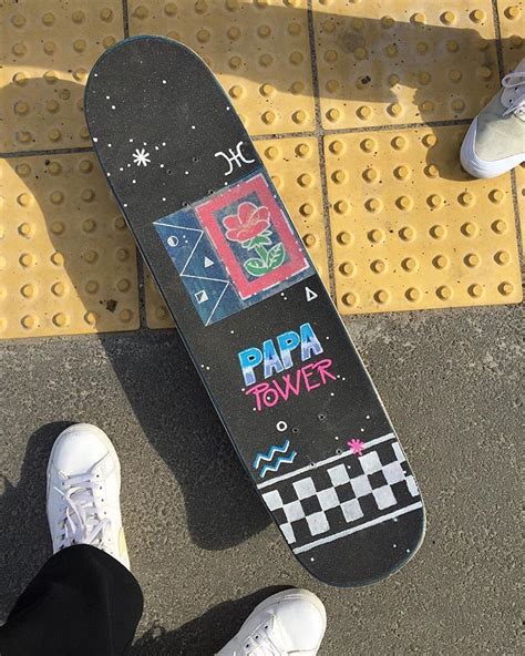 a person standing next to a skateboard with graffiti on it's bottom half