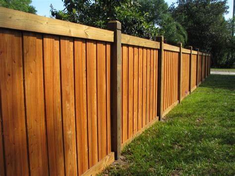 a wooden fence with white posts and wood slats on the top, along side it