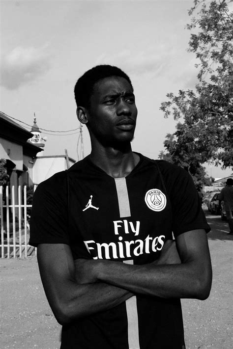 Grayscale Photo of Man in PSG Jersey With His Arms Crossed Looking Away · Free Stock Photo