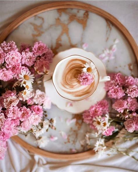 a cup of coffee and some pink flowers