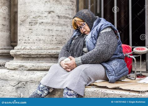 Homeless Lady Sitting On The Pavement, Reading Book Wearing A Mask ...