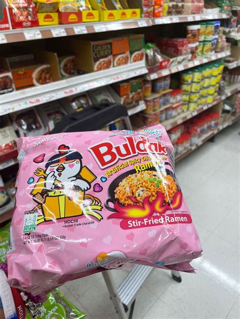 a bag of rice sitting on top of a shopping cart in a grocery store aisle