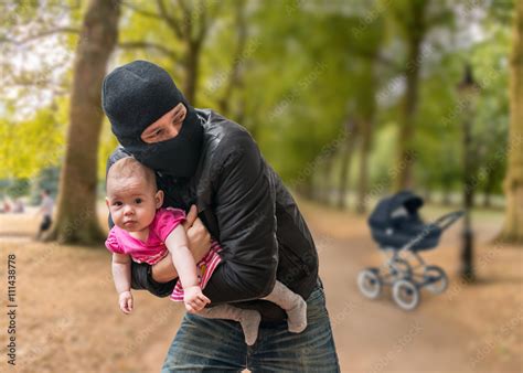 Foto de Thief is stealing kidnapped baby from stroller in park. Children kidnapping concept. do ...