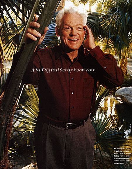 an older man is standing in front of some palm trees and smiling at the camera