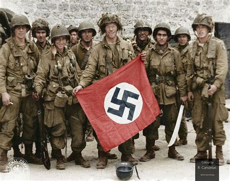 Paratroopers of US 101st Airborne Division display a Nazi flag captured in a village near Utah ...