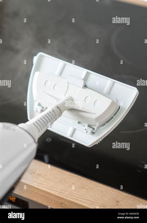 Cleaning kitchen hob with a steam cleaner Stock Photo - Alamy