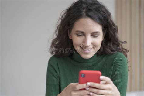 Confident Smiling Spanish Businesswoman Using Mobile Phone while Sitting at Home Office Desk ...