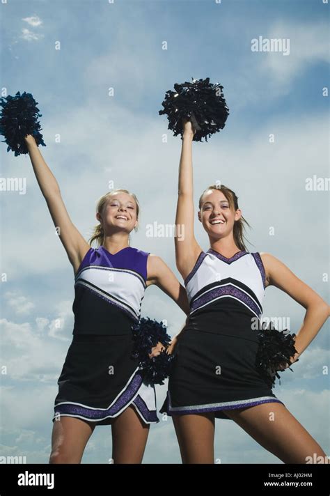 Two cheerleaders holding pom poms Stock Photo - Alamy