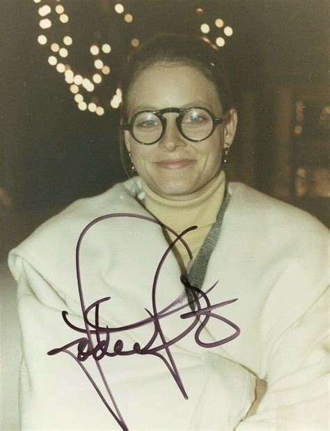 a woman wearing glasses and a white jacket