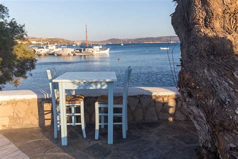 Holiday in Greece, blue table with two chairs and view of the port at a restaurant in Adamantas ...
