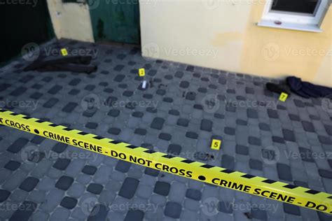 Crime scene tape for covering the area cordon. Yellow tape with blurred forensic law enforcement ...