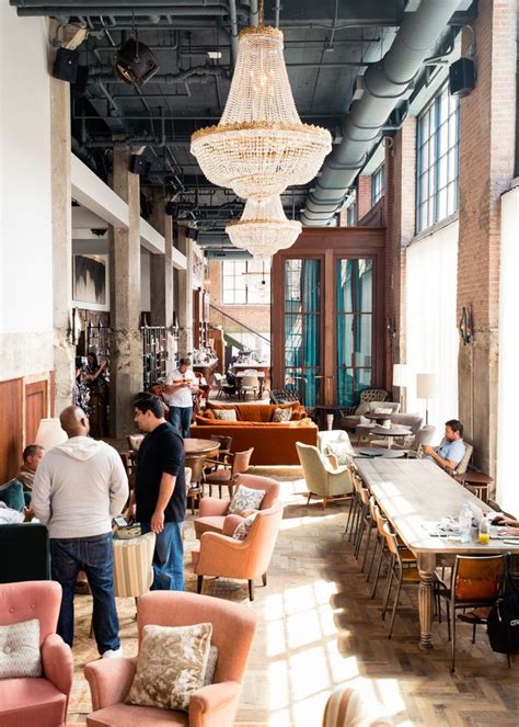 people are standing in an open room with chairs and tables