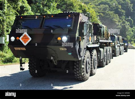 Soldiers in ammunition-laden Oshkosh M1075 Palletized Load Systems vehicles wait for the order ...