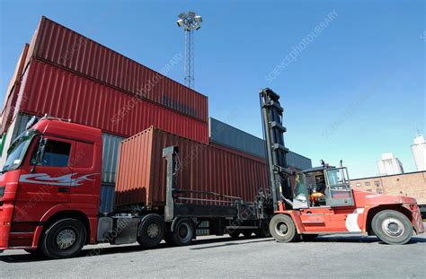 Forklift truck lifting shipping container - Stock Image - F018/5239 - Science Photo Library