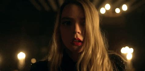 a woman with long blonde hair and lipstick on her lips in a dimly lit room