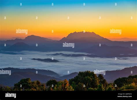 Tropical forest nature landscape view with mountain range sunrise with moving cloud mist at Huai ...