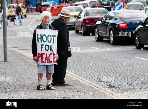 Elderly peace activist with 'Hoot for peace banner', Bristol, England ...