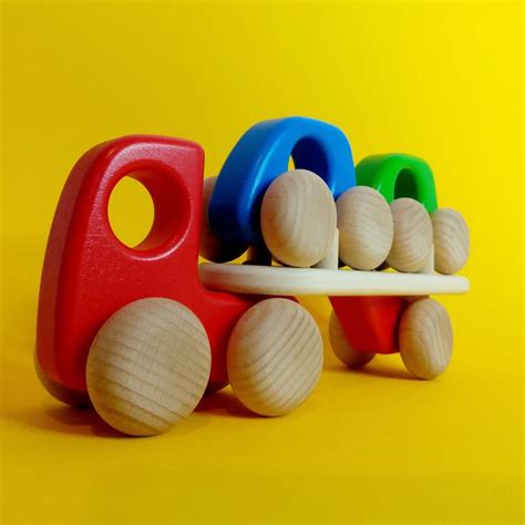 a toy train with wooden toys on the front and sides, sitting on a yellow background
