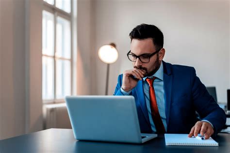 thoughtful-businessman-in-office-working-on-laptop-picture-id909203328 ...