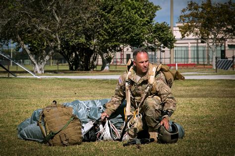 A paratrooper gathers his equipment during combat equipment jump ...