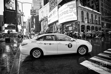 toyota camry hybrid new york yellow taxi cab crossing times square in the rain New York City USA ...