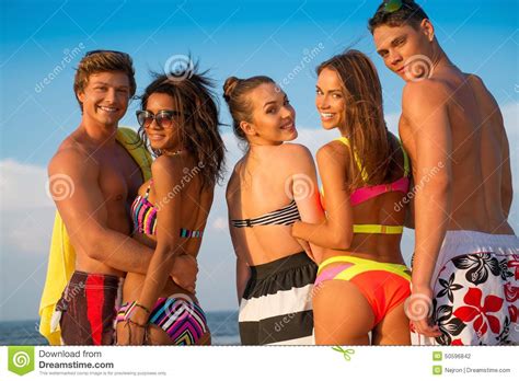 Friends walking on a beach stock photo. Image of bottle - 50596842